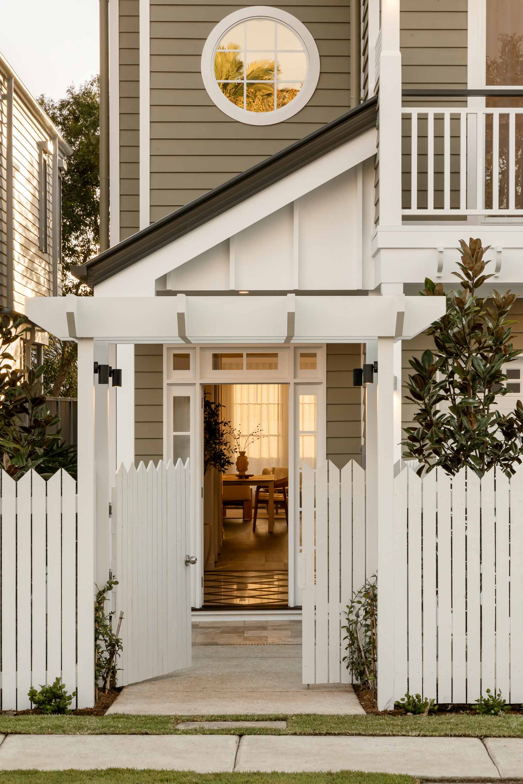 Modern Queenslander home in East Brisbane with white picket fence, open gate and warm interior entryway