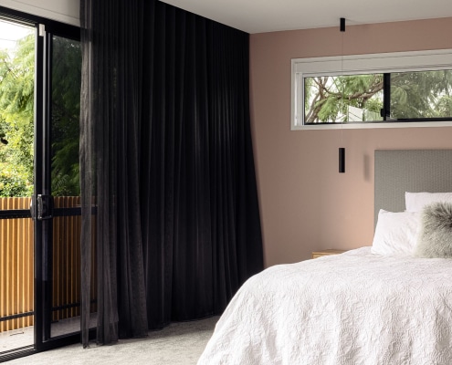 Modern bedroom in Brisbane with painted feature wall, soft neutral tones and natural light
